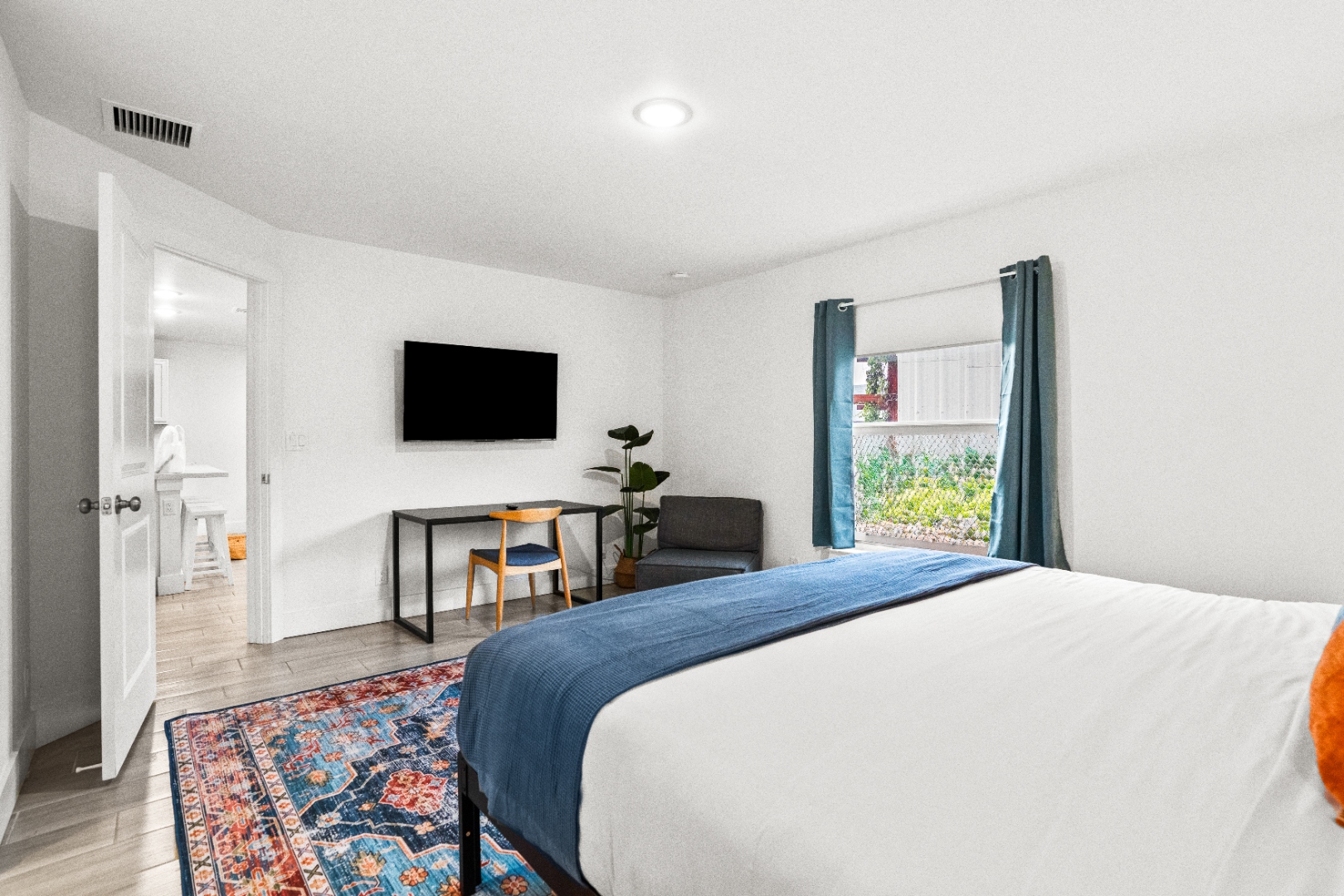 Queen bedroom with smart TV and desk